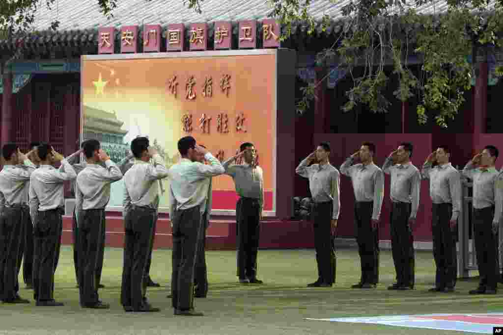 Chinese paramilitary policemen practice their salutes at a barrack near Tiananmen Gate in Beijing, June 4, 2014. 