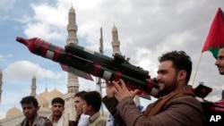 FILE - A Houthi supporter holds a mock missile during a protest marking Jerusalem Day in support of Palestinians in the Gaza Strip, in Sanaa, Yemen, April 5, 2024.