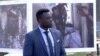 Former Congolese child soldier Michel Chikwanine examines photos of other atrocities at a peace conference in the Normandy city of Caen. (Photo: L. Bryant / VOA)