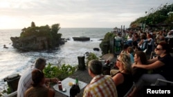 Wisatawan asing menikmati pemandangan saat matahari tenggelam di Pura Tanah Lot, Bali. (Foto: ilustrasi)