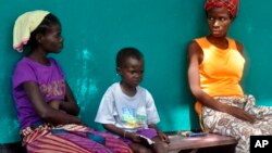 People suspected of having Ebola await treatment outside a hospital near Monrovia, Liberia, on Oct. 24, 2014. 