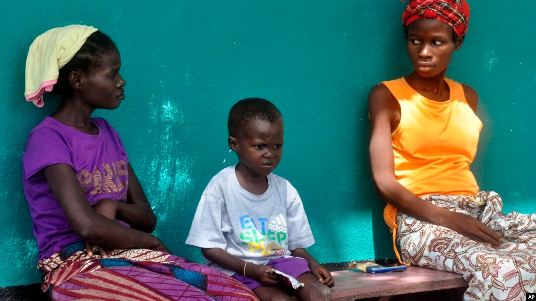 People suspected of having Ebola await treatment outside a hospital near Monrovia, Liberia, on Oct. 24, 2014. More than 10,000 people have been infected with the virus, the World Health Organization reported. 
