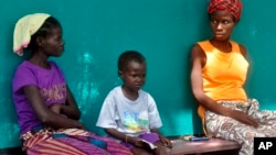 People suspected of having Ebola await treatment outside a hospital near Monrovia, Liberia, on Oct. 24, 2014. More than 10,000 people have been infected with the virus, the World Health Organization reported. 