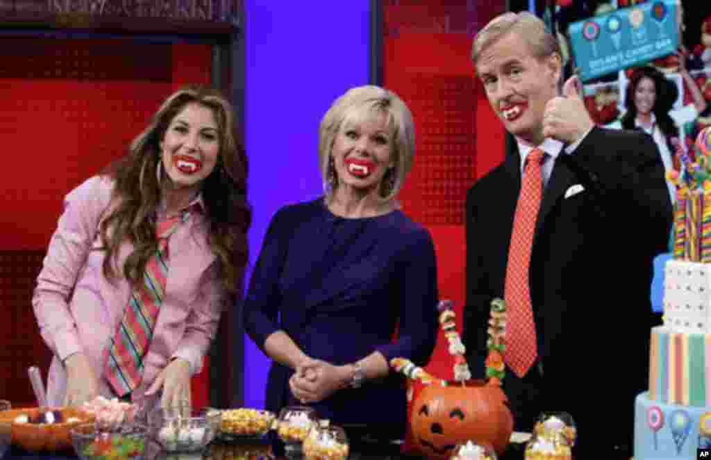 Dylan Lauren, left, CEO & Founder of Dylan's Candy Bar, wears wax lips with fangs during her appearance about Halloween candy, with program co-hosts Gretchen Carlson and Steve Doocy, on the "Fox & friends" television program on the Fox News Channel, in Ne