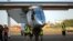 FILE - Ground crew push the Solar Impulse 2, a solar-powered airplane, toward the hangar after landing at the Kalaeloa Airport in Kapolei, Hawaii, July 3, 2015. 