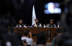 Taliban spokesman Zabihullah Mujahid, center, speaks at his first news conference in Kabul, Afghanistan, Aug. 17, 2021.