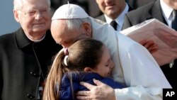 Varios niños entregaron dos regalos a Francisco: una estola de sacerdote hecha a mano y bordada por una cooperativa del barrio, que se puso de inmediato, y una pintura de la figura de la Virgen en la iglesia local, restaurada hace poco.