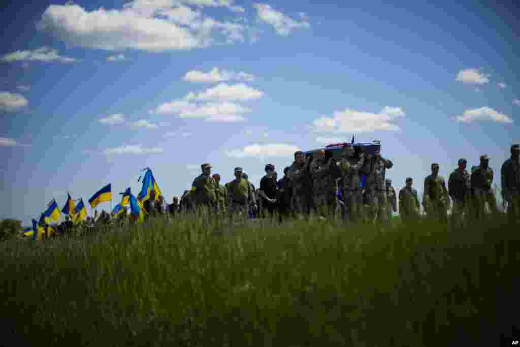 Soldados ucranianos cargan el féretro de Volodymyr Losev, de 38 años, durante su funeral en Zorya Truda, en la región ucraniana de Odesa, el 16 de mayo de 2022. El voluntario fue asesinado el 7 de mayo cuando el vehículo militar que manejaba pisó una mina en el este de Ucrania.