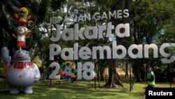 Seorang petugas kebersihan bekerja di dekat logo Asian Games 2018 di Jakarta, 17 September 2017. 