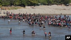 Cientos de migrantes hondureños cruzan el río Suchiate para ingresar a México, tras ser bloqueados en el puente internacional Rodolfo Robles por la Guardia Nacional mexicana, el lunes 20 de enero de 2020. AP/Moisés Castillo.