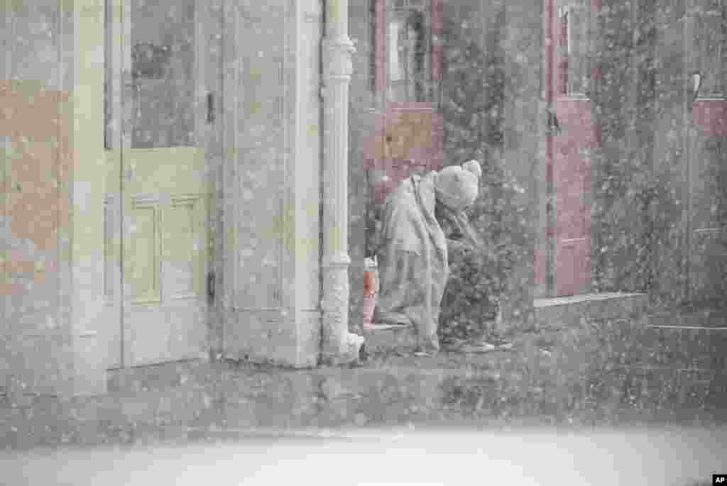 A homeless man sits in a doorway as snow falls in the French Quarter in New Orleans, Louisiana.&nbsp;A rare frigid storm is charging through Texas and the northern Gulf Coast, blanketing New Orleans and Houston with snow, closing highways and grounding nearly all flights.