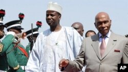 Senegalese President Abdoulaye Wade (R) and Nigerian Foreign Affairs State Minister Aliyu Idi Hong arrive in Abuja Airport to attend a special summit of Economic Community of West African States (ECOWAS), 7 Dec 2010