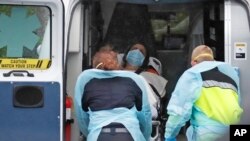 13일 미국 매사추세츠주 첼시의 한 진료소에서 신종 코로나바이러스 감염 의심 환자를 구급차에 태우고 있다.
