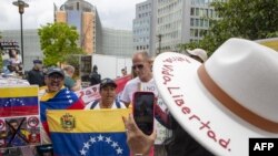 Manifestantes sostienen banderas venezolanas mientras participan en una manifestación, en el primer día de una cumbre de la Unión Europea-Comunidad de Estados Latinoamericanos y Caribeños (UE-CELAC) en Bruselas, Bélgica, el 17 de julio de 2023 .