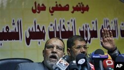 Members of the guidance council of Egyptian biggest opposition group, the Muslim Brotherhood, Essam el-Erian, left and its spokesman Mohammed Morsi attend a press conference alleging early fraud in Egypt parliamentary elections, in Cairo, Egypt, 22 Nov 20