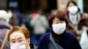 Pedestrians wear protective masks as they walk through a shopping district in Tokyo, Jan. 16, 2020. 