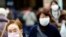 Pedestrians wear protective masks as they walk through a shopping district in Tokyo, Jan. 16, 2020. 