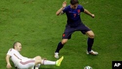 Spain's Andres Iniesta tries to reach the ball against Netherlands' Daryl Janmaat during the group B World Cup soccer match between Spain and the Netherlands at the Arena Ponte Nova in Salvador, Brazil, June 13, 2014. 