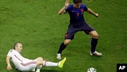 Spain's Andres Iniesta tries to reach the ball against Netherlands' Daryl Janmaat during the group B World Cup soccer match between Spain and the Netherlands at the Arena Ponte Nova in Salvador, Brazil, June 13, 2014. 