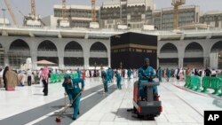 Workers clean the Grand Mosque, during the minor pilgrimage, known as Umrah, in the Muslim holy city of Mecca, Saudi Arabia, Monday, March 2, 2020. 