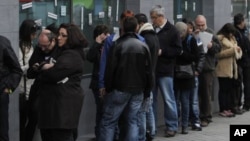 Españoles hacen fila en busca de trabajo en una oficina de empleos en Madrid.