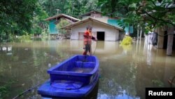 FILE - A boy catches fish in an area affected by floods in Yala province, southern Thailand, Jan. 21, 2017. Flooding in the northern and eastern regions have killed at least 23 people.