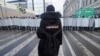 A man with a sign 'Navalny' on his back stands in front of riot policemen blocking the way to protester during a protest against the jailing of opposition leader Alexei Navalny in St. Petersburg, Russia, Jan. 31, 2021.