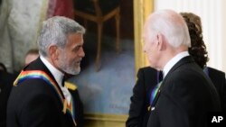 Aktor George Clooney menjabat tangan Presiden AS Joe Biden saat menerima penghargaan dalam sebuah acara di Gedung Putih, Washington, pada 4 Desember 2022. (Foto: AP/Manuel Balce Ceneta)