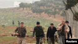 Combatientes portan sus armas mientras avanzan hacia sus posiciones cerca de la línea de frente contra las fuerzas leales al presidente sirio Bashar al-Assad en la aldea de Ratian, al norte de Alepo el 17 de febrero de 2015.