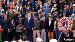Presiden Perancis Emmanuel Macron (kiri) dan Presiden AS Donald Trump dalam peringatan 75 tahun "D-Day" di taman makam pahlawan Colleville-sur-Mer, Normandy, Perancis, Kamis (6/6). 