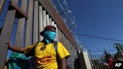 Migrants gather at the Mexico-U.S. border after getting past a line of Mexican police at the Chaparral crossing in Tijuana, Mexico, Nov. 25, 2018, as they try to reach the U.S. 