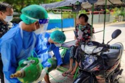 میانمار میں کرونا وائرس کے ایک مریض کی سانس بحال کرنے کے لیے طبی عملہ اسے آکسیجن دے رہا ہے۔