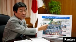 Japan's Economy, Trade and Industry Minister Toshimitsu Motegi, points to a board showing an overview of countermeasures planned for Tokyo Electric Power Co. (TEPCO)'s tsunami-crippled Fukushima Daiichi nuclear power plant, during an interview with Reuter