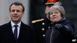 Perdana Menteri Inggris Theresa May (kanan) menyambut Presiden Perancis Emmanuel Macron sebelum pembicaraan bilateral di Sandhurst, Inggris, Kamis (18/1). 