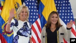 Las primeras damas de EEUU, Jill Biden, a la izquierda, y Ecuador, María de Lourdes Alcívar, saludan a la prensa desde el Palacio Presidencial, en Quito, el 19 de mayo de 2022.
