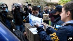 Policías confiscan una caja de documentos durante un allanamiento judicial en el Hotel Plaza Central donde se aloja la tripulación de un avión de carga Boeing 747 de propiedad venezolana, en Buenos Aires, Argentina, el martes 14 de junio de 2022.
