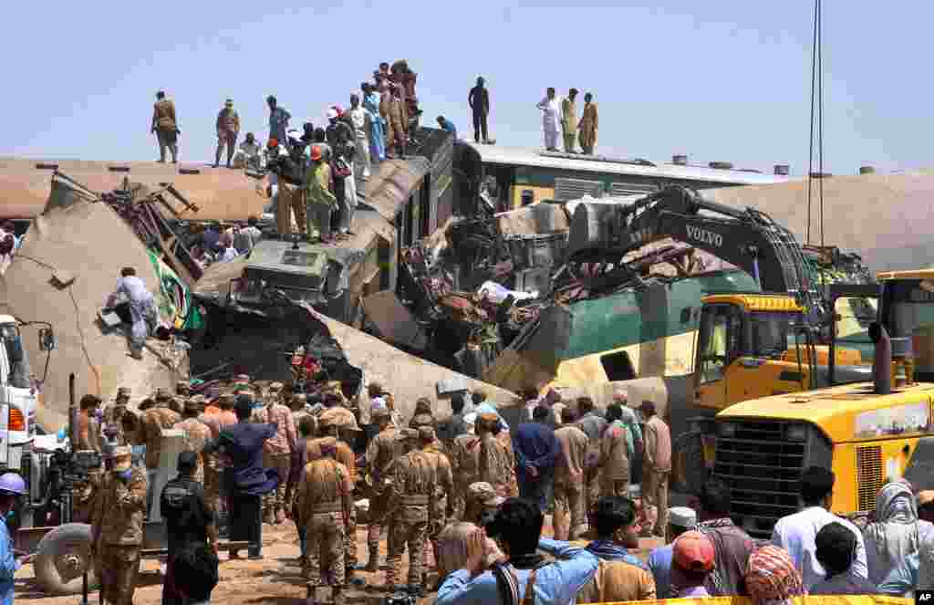 Soldiers and volunteers work at the site of a train collision in the Ghotki district in southern Pakistan. Authorities said at least 51 people were killed and more than 100 others injured in a train collision in southern Sindh province. 
