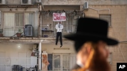 Una efigie del líder de Hamás, Yehya Sinwar, cuelga del balcón de un apartamento bajo el cartel "Indeseado", en Jerusalén el jueves 28 de marzo de 2024. 