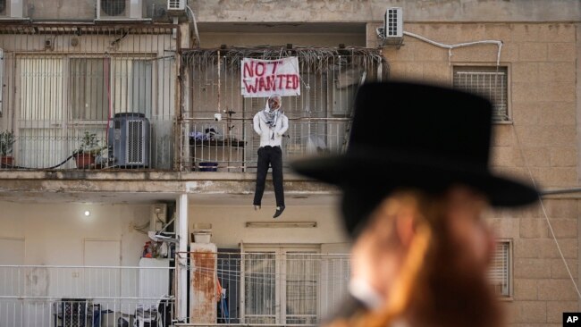 Una efigie del líder de Hamás, Yehya Sinwar, cuelga del balcón de un apartamento bajo el cartel "Indeseado", en Jerusalén el jueves 28 de marzo de 2024. 