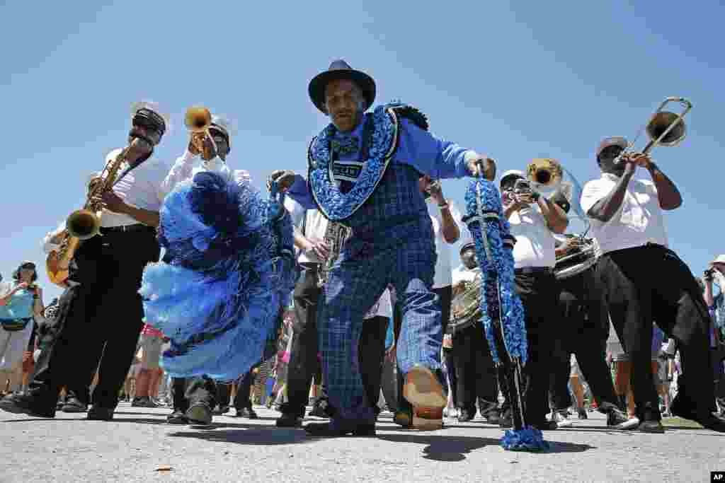 Members of the Keep N It Real Social Aid &amp; Pleasure Club march with the New Wave Brass band at the New Orleans Jazz and Heritage Festival in New Orleans, Louisiana.