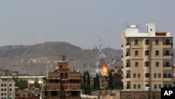 Debris and smoke rise after a Saudi-led airstrike hits an army base in Sana'a, Yemen, Sept. 14, 2015. 