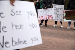 Students hold signs during a Speak Out Against Sexual Violence demonstration at Eastern Michigan University in Ypsilanti, Michigan, March 28, 2021.