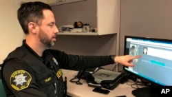 In this Feb. 22, 2019, photo, Washington County Sheriff’s Office Deputy Jeff Talbot demonstrates how his agency used facial recognition software in Hillsboro, Oregon. (AP Photo/Gillian Flaccus)