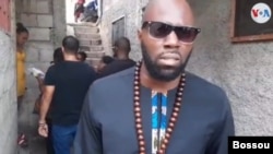 French Beninese writer, activist Kémi Seba distributes sanitary kits to Port au Prince slum, Nov 16, 2019. (Photo W.Bossou/ VOA Creole)