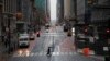 A commuter crosses 42nd Street in front of Grand Central Terminal during what is typically morning rush hour, in New York, March 23, 2020.