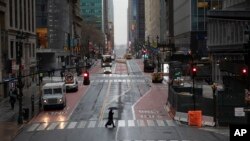 A commuter crosses 42nd Street in front of Grand Central Terminal during what is typically morning rush hour, in New York, March 23, 2020.