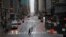 A commuter crosses 42nd Street in front of Grand Central Terminal during what is typically morning rush hour, in New York, March 23, 2020.
