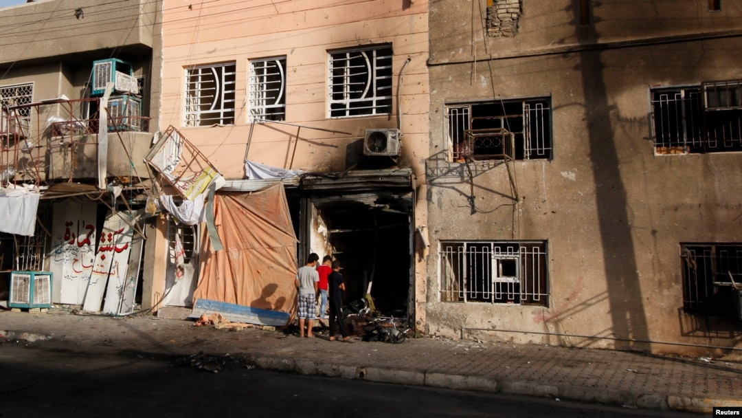Anak-anak laki-laki tengah memeriksa lokasi terjadinya serangan bom di wilayah Tobchi, Baghdad (21/7). Sedikitnya 46 orang dilaporkan tewas dalam gelombang serangan bom mobil di beberapa kawasan kota Baghdad, Sabtu malam.