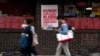 FILE - People pass a sign protesting the construction of a sports arena, in the Chinatown neighborhood of Philadelphia, Pennsylvania, Sept. 18, 2024. 