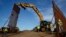 FILE - Construction crews install new border wall sections, Jan. 9, 2019, seen from Tijuana, Mexico. 